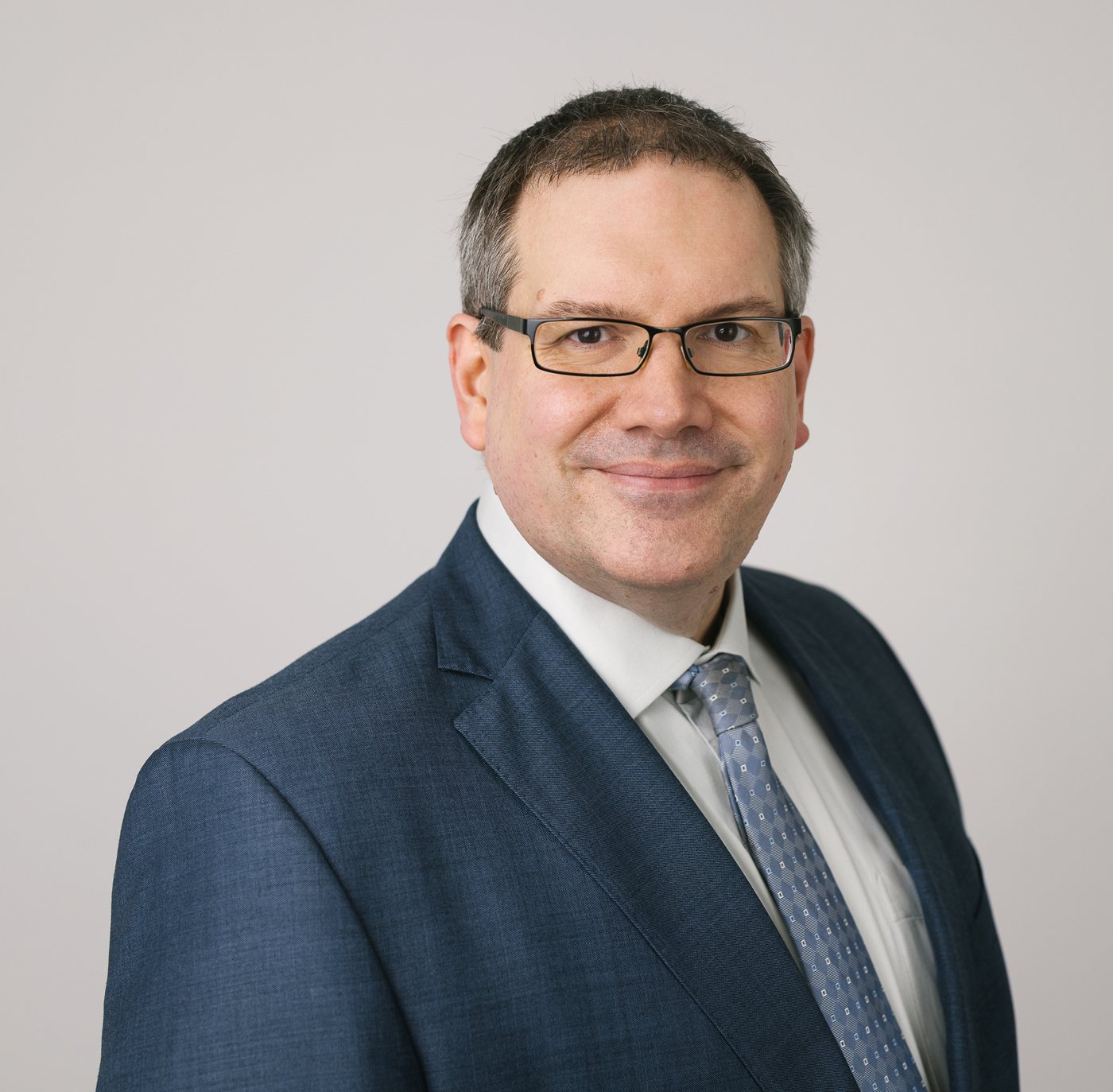 Dr. Roland Müller, MBA, im dunkelblauen Anzug, Porträt